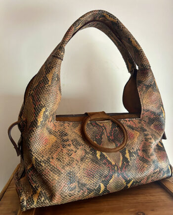 Bolso de hombro en piel de cordero con print de serpiente combinado con ante color arce. Detalle de adorno redondo forrado en ante en el cierre, con cremallera y bolsillo interior: ligero y con capacidad. Tacos de apoyo en la base01